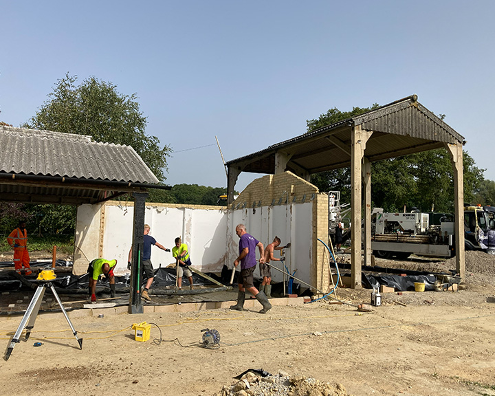 man in a black sweater with St Pierre Contractors logo smiling against a plain background showcasing professionalism and reliability in construction services 5 key qualities